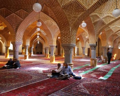 TOPSHOT - A picture taken on April 24, 2018 shows Iranians reading the Quran as they sit in a mosque in the city of Tabriz in Iran's northwestern East-Azerbaijan province. - The historic Tabriz bazaar complex, located along one of the most frequented east-west trade routes, consists of a series of interconnected, covered brick structures, buildings, and enclosed spaces for a variety of functions: commercial and trade-related activities, social gatherings, and educational and religious practices. (Photo by ATTA KENARE / AFP)        (Photo credit should read ATTA KENARE/AFP/Getty Images)